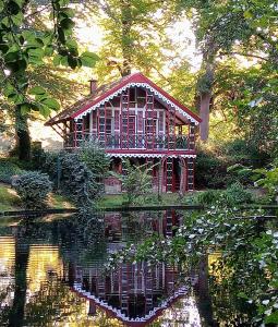 a small house sitting on top of a pond in front of a house at MeerMomente in Dorum Neufeld +23 photos
