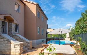 uma piscina com uma mesa e um guarda-chuva ao lado de uma casa em 6 Bedroom Nice Home In Babici em Babići