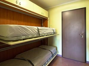 puste łóżko piętrowe w pokoju z drzwiami w obiekcie Capanna w mieście Prato Nevoso