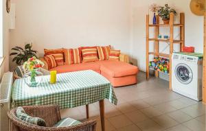 a living room with a couch and a table and a washing machine at Stunning Home In Grzybowo in Grzybowo