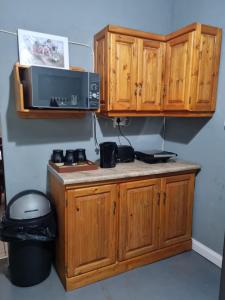 cocina con armarios de madera y microondas en Abaloo Apartment #1, en Sabie