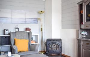 a living room with a chair and a stove at Beach Front Home In Jondal With House Sea View in Jondal