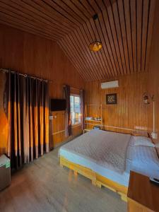 ein Schlafzimmer mit einem großen Bett in einem Holzzimmer in der Unterkunft Catba Oasis Bungalows in Cát Bà