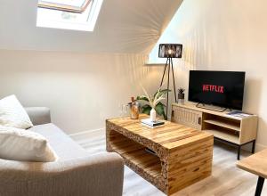 a living room with a couch and a television at Luxury Scandi Inspired 1 Bed Town Centre Apartment in Bournemouth