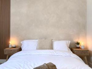 ein Schlafzimmer mit einem weißen Bett und zwei Nachttischen in der Unterkunft Luxury Scandi Inspired 1 Bed Town Centre Apartment in Bournemouth