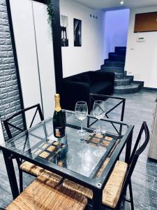 un tavolo di vetro con una bottiglia di vino e due bicchieri di Residence Toraldo a Roma