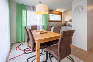 Un comedor con mesa y sillas de madera. en LAAX Homes - Casa Lanezzi 3, en Flims 8 fotos más