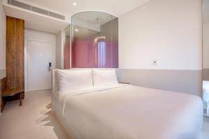 Postel nebo postele na pokoji v ubytování Wink Hotel Saigon Centre - 24hrs Lifestyle Stay