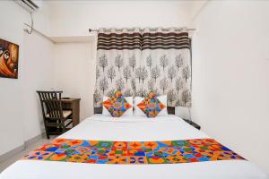 a bedroom with a bed with a colorful blanket on it at FabHotel Vardhan House II in Dāpuri