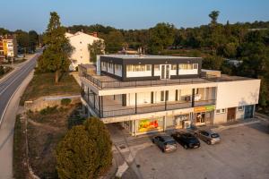 an aerial view of a house with two cars parked in a parking lot at Hostel Potpican in Potpićan