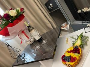una mesa con ensalada de frutas y un jarrón de flores en LUXSUITES, en Ofrinion