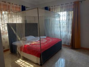 a bed with a canopy in a room at Charming House in Matugga Kampala Uganda in Matuga