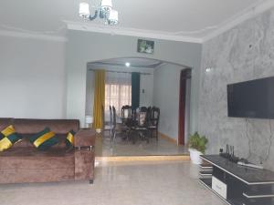 sala de estar con sofá y comedor en Charming House in Matugga Kampala Uganda en Matuga