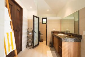 ein Badezimmer mit einem Waschbecken und einem großen Spiegel in der Unterkunft Virgin Beach Resort in San Juan