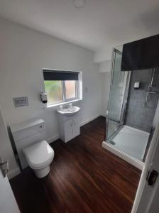 a bathroom with a toilet and a shower and a sink at City Apartments Charles Street in Hull