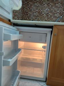 an empty refrigerator with its door open in a kitchen at Asterias Studios in Astris