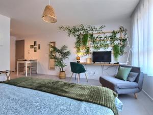 um quarto com uma cama, um sofá e uma secretária em LE RIVIERA - Roissy CDG - Parc Astérix - Paris em Moussy-le-Neuf