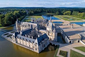 uma vista aérea de um castelo na água em LE RIVIERA - Roissy CDG - Parc Astérix - Paris em Moussy-le-Neuf