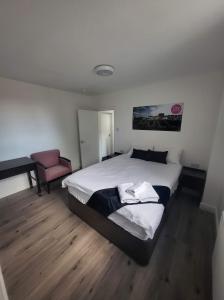 a bedroom with a large bed and a chair at City Apartments Charles Street in Hull