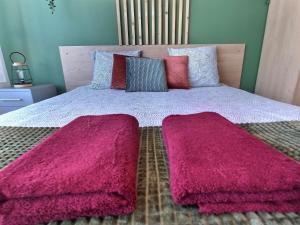 uma cama com cobertores cor-de-rosa em cima em LE RIVIERA - Roissy CDG - Parc Astérix - Paris em Moussy-le-Neuf