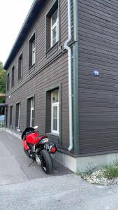 a red motorcycle parked in front of a building at Delta11 - 2 bedrooms, 2 big beds, 1 single bed in Tartu
