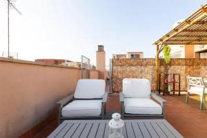 two white chairs sitting on a rooftop patio at Apt.p/5 15min from Barcelona and Beaches W/Terrace in Sant Adria de Besos