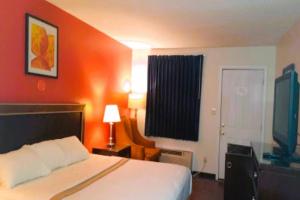 Habitación de hotel con cama y TV en OYO Hotel McIntyre GA, US 441, en McIntyre
