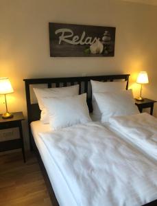 Duas camas com lençóis brancos e almofadas num quarto em Relax am Bodensee em Friedrichshafen