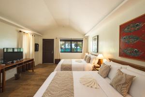 ein Hotelzimmer mit 2 Betten und einem TV in der Unterkunft Virgin Beach Resort in San Juan