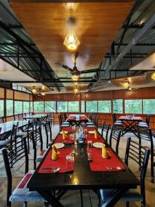 una sala da pranzo con un lungo tavolo e sedie di Forest and River Edge Resort a Kannur