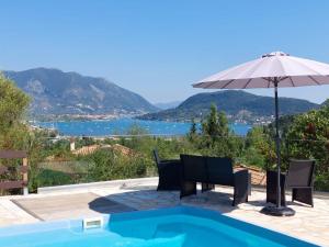a patio with an umbrella and chairs next to a swimming pool at Villa Avlaki in Vlikhón