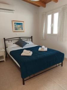 1 dormitorio con 1 cama grande y 2 toallas. en Villa Avlaki, en Vlikhón