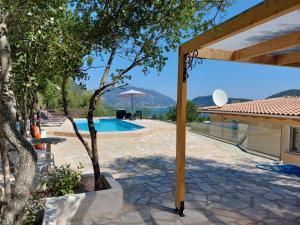 a patio with a pool and trees and a house at Villa Avlaki in Vlikhón
