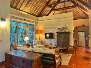 sala de estar con sofá y mesa en Desa Kerasan 5 -Luxury 2BRV 15 mins to Ubud, en Ubud