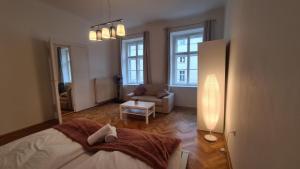 a bedroom with a bed and a couch and windows at commodious 3BR Apt. Ideal for Families and Friends in Vienna