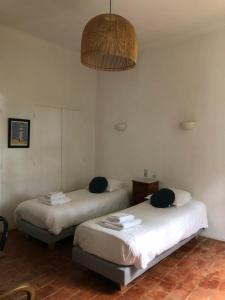2 camas en una habitación con espejo y lámpara en Château la Sable, chambres d'hôtes, en Cucuron