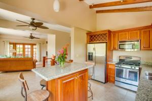 a kitchen with wooden cabinets and a counter with flowers on it at Placencia Pointe Townhomes #6 in Placencia Village