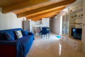 een woonkamer met een blauwe bank en een keuken bij CASA TERESA NEL CENTRO DI VIETRI in Vietri
