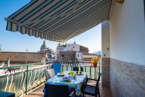 a table on a balcony with a view of a city at CASA TERESA NEL CENTRO DI VIETRI in Vietri