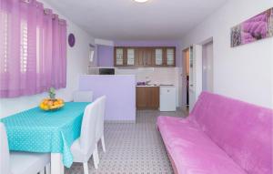 1 Bedroom Beautiful Apartment In Jelsa في ييلسا: غرفة معيشة مع طاولة وأريكة أرجوانية
