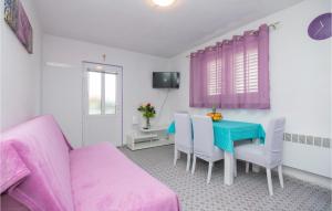 1 Bedroom Beautiful Apartment In Jelsa في ييلسا: غرفة معيشة مع طاولة وأريكة وردية