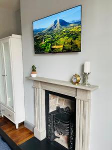 a living room with a fireplace with a tv above it at Old Dublin ‘Four sisters’ in Dublin