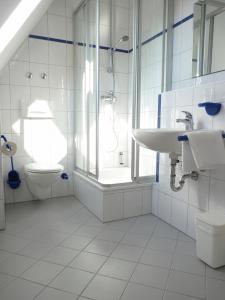 a white bathroom with a sink and a toilet at Gasthaus zum Schloßwirt in Dietfurt