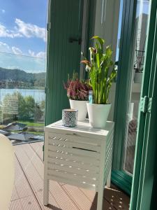 two plants on top of a white dresser on a porch at BrixHome in Laveno-Mombello