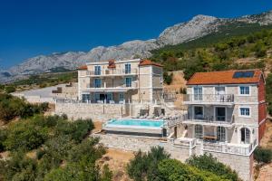 a large house with a swimming pool on a hill at Heritage Hotel Liberan in Podgora