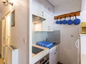 a small kitchen with white cabinets and a sink at Joli studio 6 personnes au pied des pistes - FR-1-400-54 in Gourette +4 photos