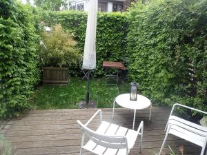 a patio with chairs and a table and an umbrella at Ferienwohnung Holzmaden Am Platz in Holzmaden