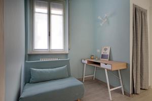 a room with a chair and a desk and a window at Casa Luna in Novara