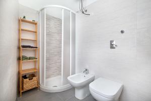 La salle de bains blanche est pourvue d'une douche et de toilettes. dans l'établissement Casa Luna, à Novara