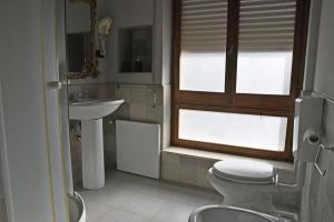 łazienka z toaletą, umywalką i oknem w obiekcie Barocco al centro w Katanii +4 zdjęcia